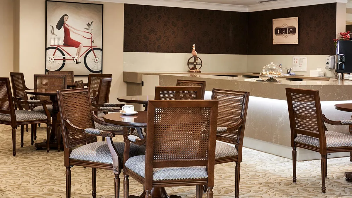  Luigi classic cane back dining armchairs, with beech wood structure stain in walnut tone, in a senior living dining area