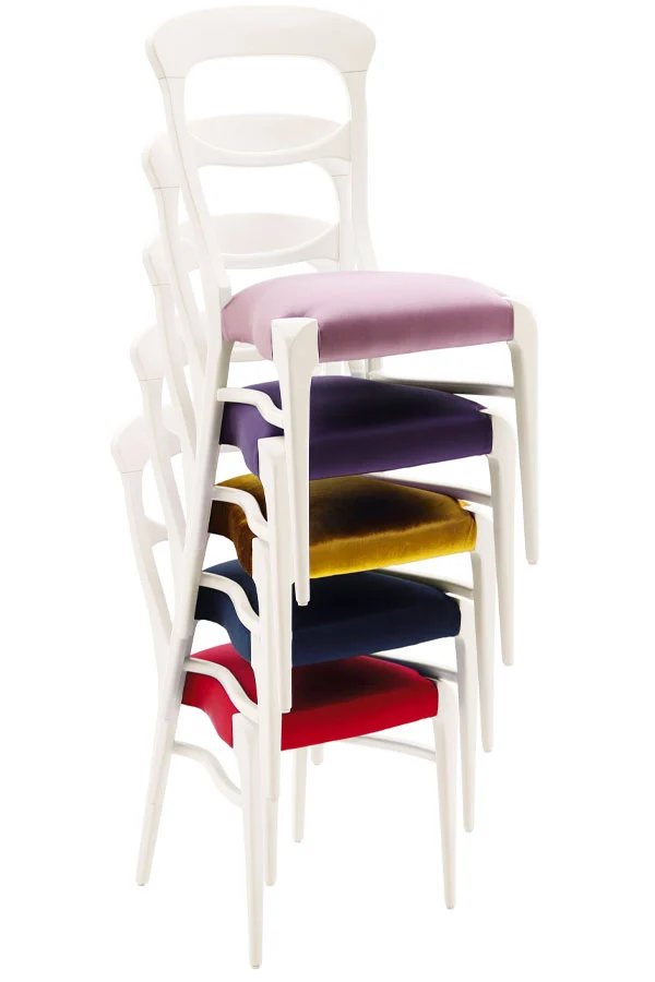 Set of five stackable contemporary dining chairs with white wooden frames and seats upholstered in assorted multicolor fabrics