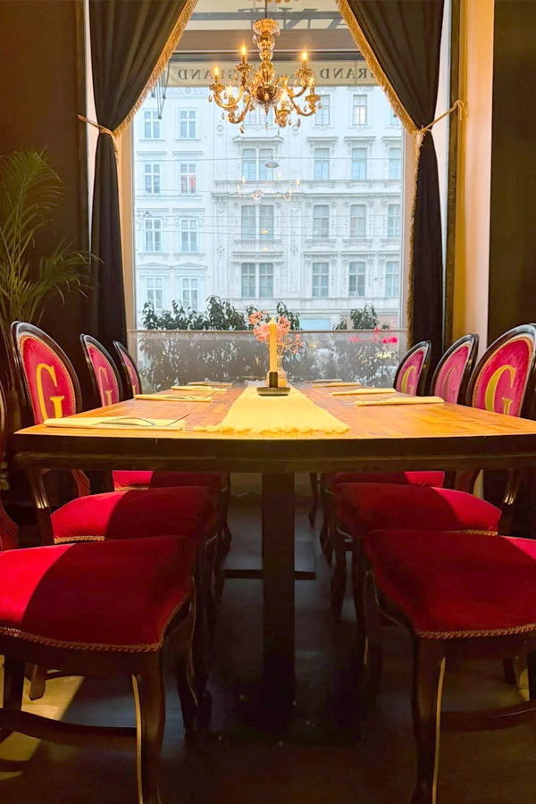 Stackable Liberty chairs in red velvet with a logo in the Grand Restaurant in Vienna, Austria.