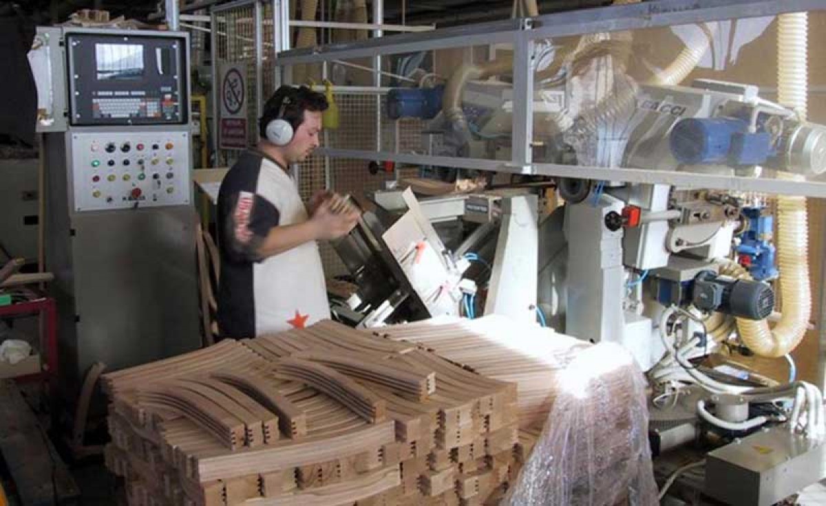 An operator drilling a classic chair at Sevensedie in Italy