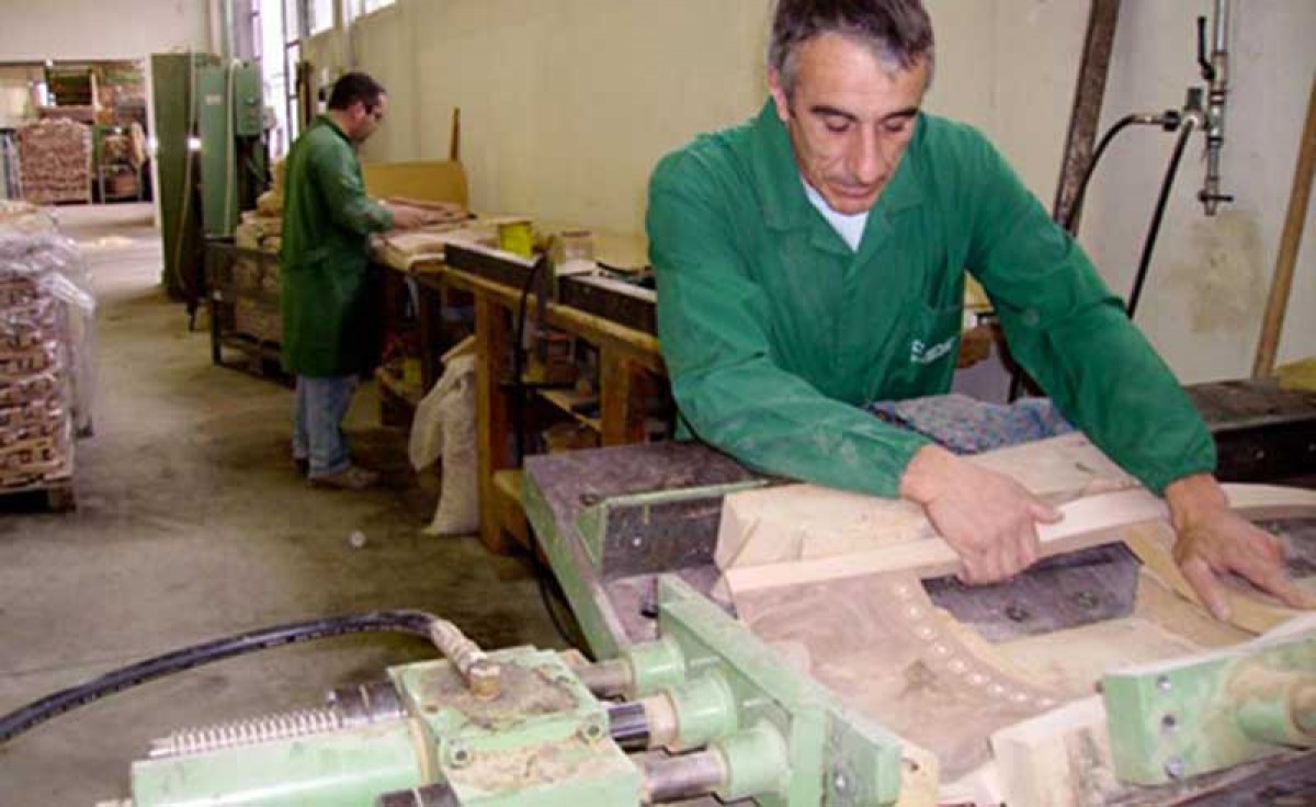 An operator assembling the backrest of a wooden classic chair at Sevensedie in Italy
