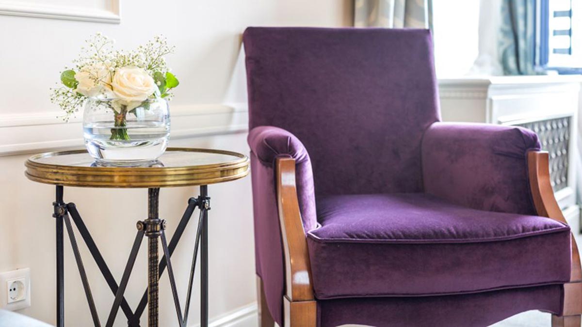 Edea contemporary armchair upholstered in violet velvet next to a beautiful cast iron lamp table with glass top. Comfortable armchair 100% made in Italy. by Sevensedie